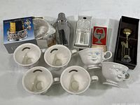 Top down view showing all items in the lot including the six Baileys cups, cocktail shaker, bottle coaster and stoppers, and openers.