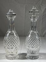 Two 11 inch cut crystal decanters side by side showing their size and design similarity with different stoppers.