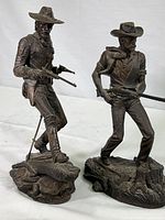 Two full view bronze sculptures of The Cavalryman and The Rifleman on white background, about 10.5 inches tall, showing gun positions and bases.