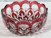 Front angled view of the ruby red and clear crystal hand cut bowl showing the scalloped rim and detailed cut patterns.