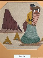 Close-up of sand art showing Navajo woman carrying a child in cradleboard with mountain background.