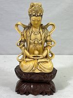 Front view of the statue showing seated meditative figure and dark lotus base