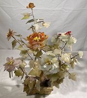 Full view of vintage Chinese jade tree sculpture showing multiple stems with stone leaves and flowers, mounted on a stone base.
