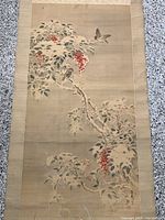 Full view of the vintage Japanese painted scroll showing the floral and bird motif with red berries and green leaves on a beige background.