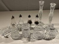 Image of all table items including candlesticks, salt and pepper shakers, cream and sugar set, spoon rest, covered dish arranged on table