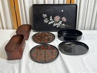 Full view of all items including lacquer trays and plates, oval dish, and woven baskets.