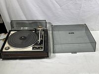 Front and top view showing the whole Garrard Zero 92 turntable with tonearm, platter, and dust cover removed and placed to the side.