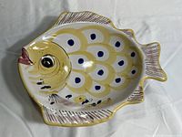 Top view of the fish-shaped ceramic bowl showing detailed yellow trim and blue dot patterns on white ceramic body.