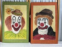 Photo of both pastel clown paintings side by side, showing orange and green frames, and distinctive clown faces