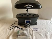 Full view of AeroGarden with adjustable height light, digital control panel, power cord, plant food, and instruction manual visible