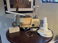 Full view of Bosch food processor with main mixing bowl, whisk, dough hook, beater, meat grinder attachment, and slicer/shredder discs.