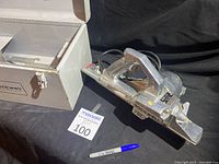 Plane and closed metal carrying case shown side by side on black backdrop