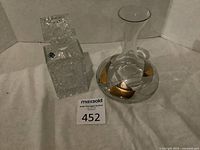 Square lead crystal decanter with sticker and rounded glass decanter with leaf design.