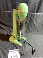 Front view of the green Hamilton Beach Drink Master including the stainless steel mixing container and attached power cord