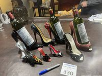Photo showing all high heel shoe wine bottle holders and smaller shoe bar accessories with wine bottles set inside the holders