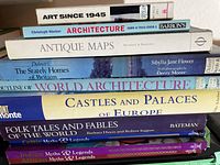 Stack of art, architecture, maps, and history books showing titles and authors on spines.