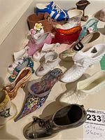 View of whole lot showing multiple collector shoes of various colors, materials, and styles arranged close together on white surface