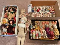Three boxes containing an assortment of vintage dolls and one larger cloth-bodied porcelain head doll at center