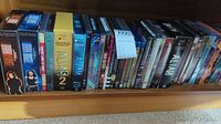 Shelf view of collectible DVD and VHS sets including Alias, Dark Angel, and other titles showing box and case designs.