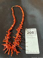 Full view of necklace laid flat with MaxSold lot tag showing 10 inch length.