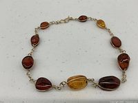 Full view of amber link bracelet laid flat to show bead shapes and wire links