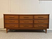 Front view of teak 9-drawer dresser showing nine drawers and tapered legs