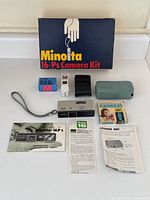 Full kit laid out showing camera, case, flashgun, batteries, flash bulbs, manuals, and original box.