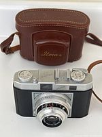 Front and case view of the vintage Photrix 35mm film camera and brown Iloca leather case.