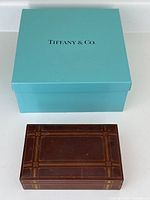 Photo showing entire lot including the Tiffany & Co. blue cardboard box and leather humidor in front of it.