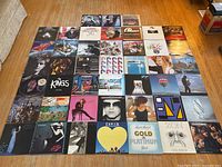 Grid of various vinyl LP album covers arranged on floor