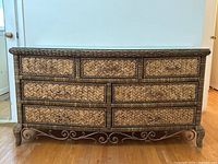 Front view of the wicker chest without glass top, showing seven drawers with woven fronts and wrought iron base design.