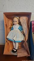Alice in Wonderland Madame Alexander doll in blue dress and white apron in box with peach tissue paper
