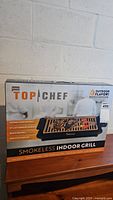 Photo of full boxed indoor grill showing front branding and product image.