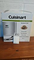 Front view of the unopened Cuisinart Sandwich Grill box showing model details, features, and branding.
