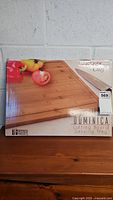 New unopened boxed Grande Chef Dominica bamboo cutting board with image of cutting board featuring tomatoes and bell peppers on surface.