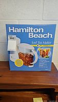 Front view of the unopened Hamilton Beach Iced Tea Maker box showing the brand, product name, and a clear pitcher with iced tea and lemon images.