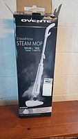 Photo showing the Ovente Steamfresh Steam Mop in original packaging, box is opened but unopened inside.