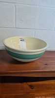 Side view of the round ceramic mixing bowl showing green and cream bands.