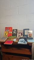 Photo of vintage books arranged on a wooden surface, showing a variety of classic literature covers including Mark Twain and others.
