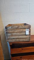 Side view of vintage wooden crate showing solid slatted wood construction and natural aging marks.
