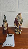 Front view of both Walnut Ridge wood carved Santa figurines showing their detailed painting and condition.