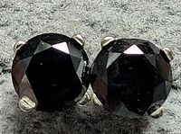 Close-up front view of both black diamonds in prong settings