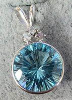 Close-up front view of pendant showing blue topaz and setting