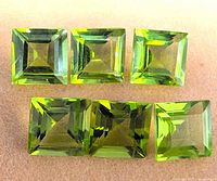 Front view of six square-cut peridot gemstones laid out in two rows.