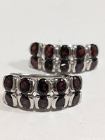 Close-up image of one earring showing two rows of oval garnet stones set in silver.