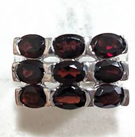 Front view of the silver ring with nine oval garnet stones arranged in three rows