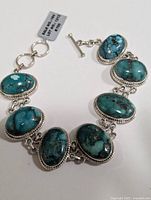 Full view of turquoise and silver bracelet showing all seven stones and toggle clasp.