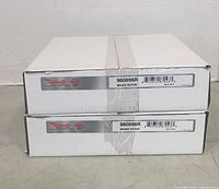 Two Raybestos brake rotors model 980896R in white boxes with labels visible, stacked one on another on flat surface.