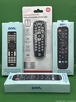 Photo of four universal remote controls, three Onn-brand (two boxed, one loose) and one GE-brand remote in package.
