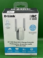 Front of the boxed D-Link AC1200 Mesh Wi-Fi Range Extender showing product image, brand, model, and features like mesh smart roaming and AC1200 dual-band wireless.